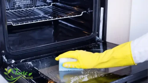 "Weekly oven glass cleaner maintenance routine - wiping exterior oven door with microfiber cloth and spray bottle"